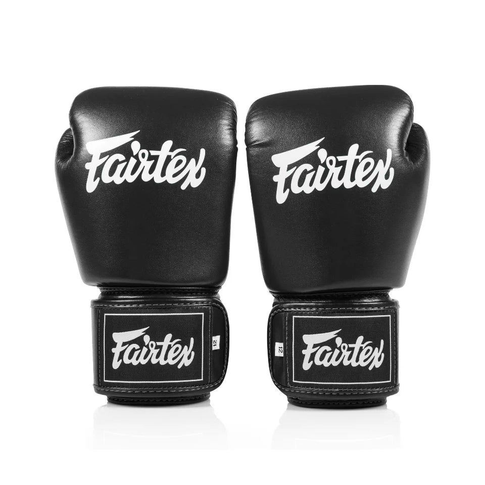 Pair of black Fairtex boxing gloves on a white background