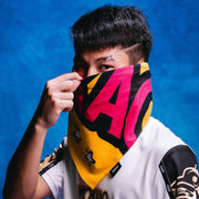 Person holding a colorful bandana with abstract design against a blue background