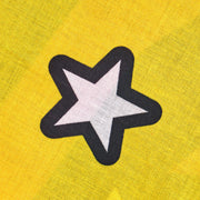 Star-shaped patch with black outline on a yellow fabric background