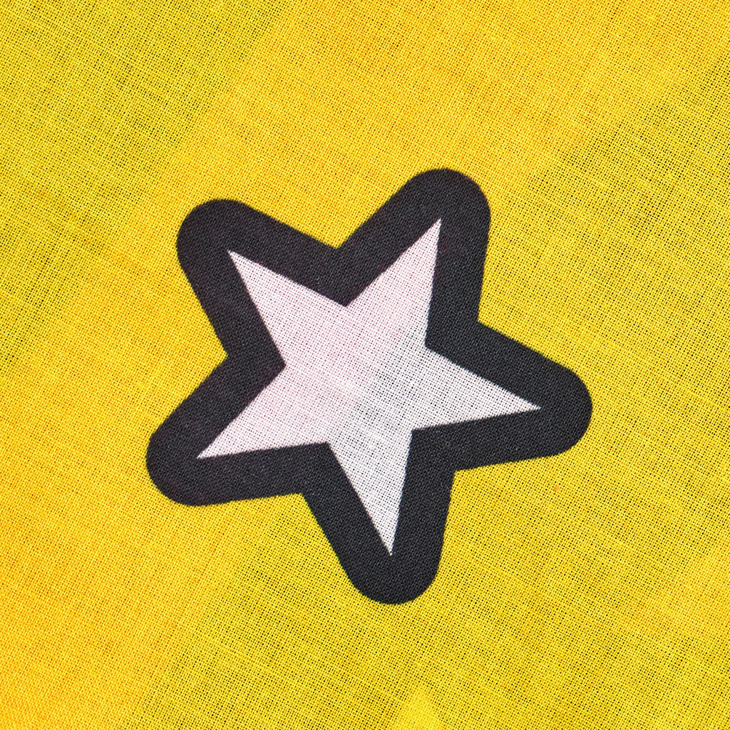 Star-shaped patch with black outline on a yellow fabric background