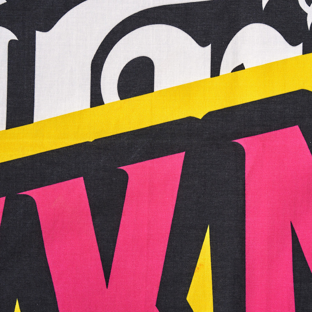 Close-up of colorful text with pink, yellow, and white letters on a black background
