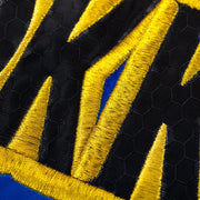 Close-up of black and yellow patterned fabric with blue background