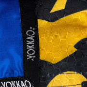 Close-up of YOKKAO branding on a blue and yellow martial arts gi.