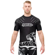 Man wearing a black athletic shirt with white graphics and 'Yokkao' branding on a white background