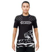 Person wearing a black Yokkao athletic shirt with a tiger design on a white background