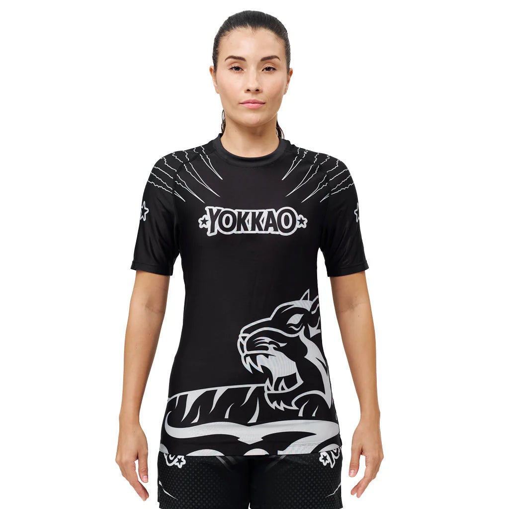 Person wearing a black Yokkao athletic shirt with a tiger design on a white background