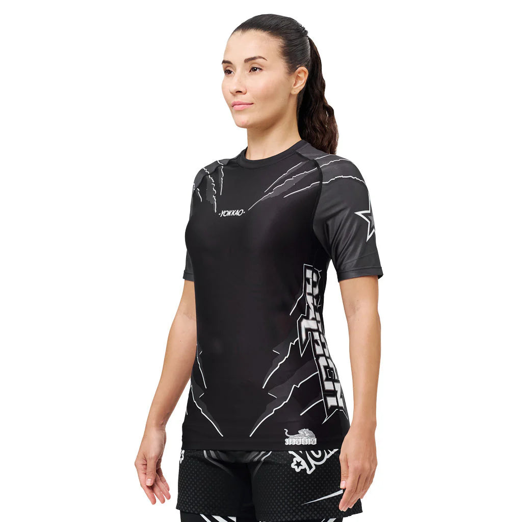 Woman wearing a black athletic outfit with branding on a white background