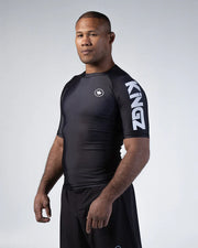Man wearing a black athletic outfit with 'Kingz' branding on a gray background