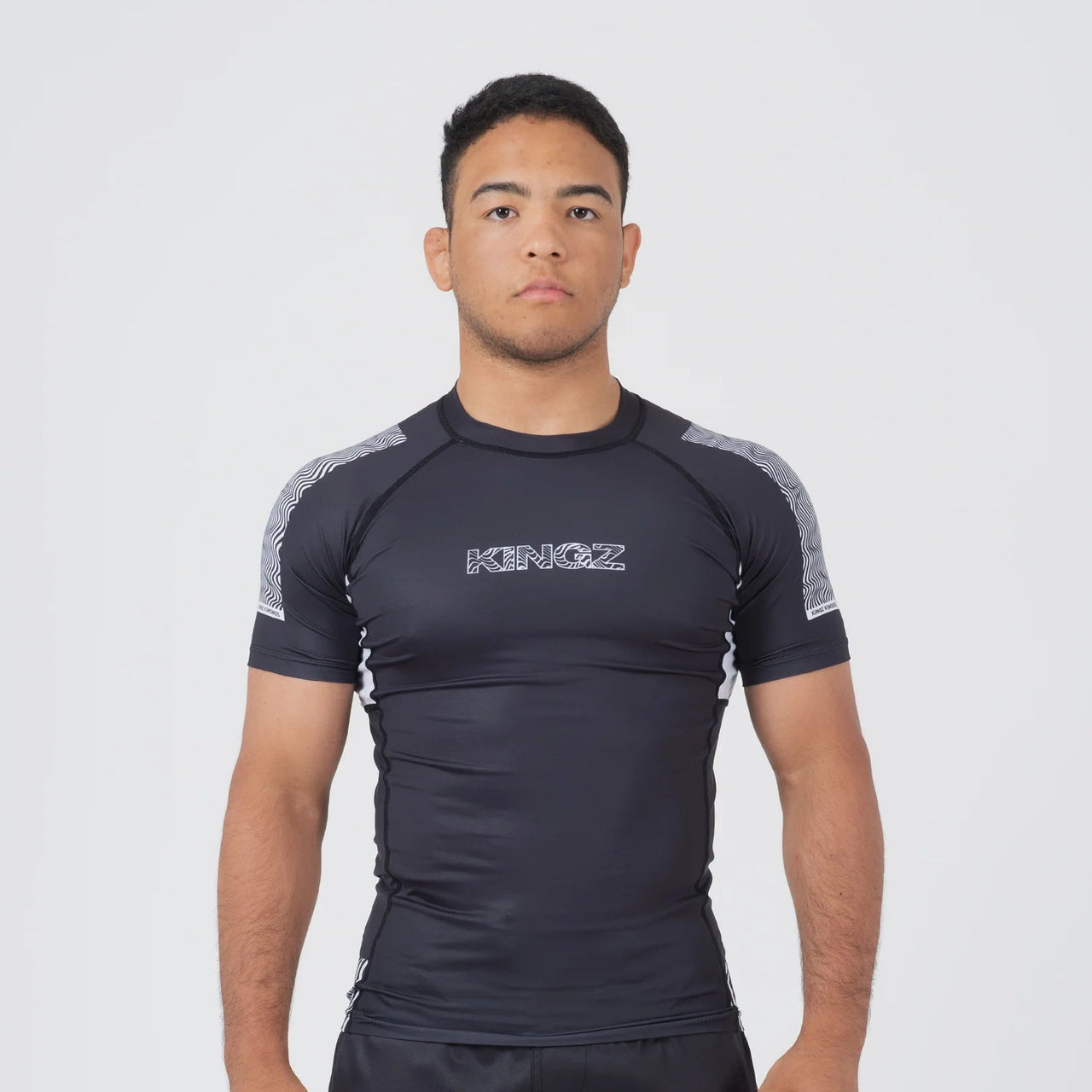 Person wearing a black athletic outfit with 'KINGZ' branding on a white background