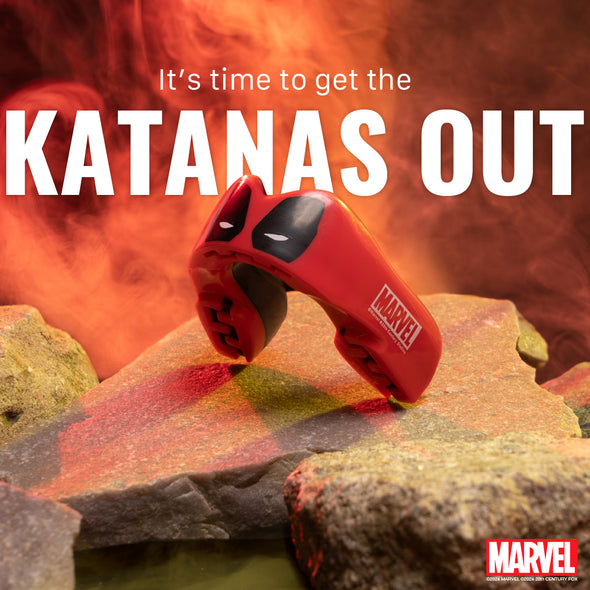 Red toy sword with 'Marvel' logo on a rocky surface with fiery background