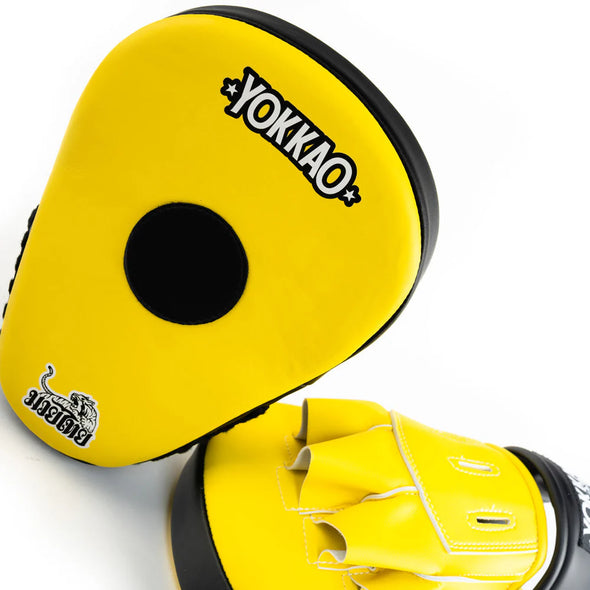 Yellow boxing mitts with black center and 'Yokkao' branding on a white background