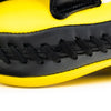 Close-up of a yellow and black shoe with stitching detail on a white background