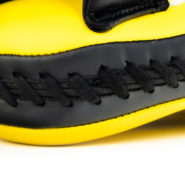 Close-up of a yellow and black shoe with stitching detail on a white background