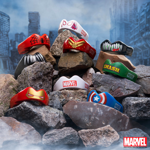 Marvel-themed hats on rocks with a cityscape background