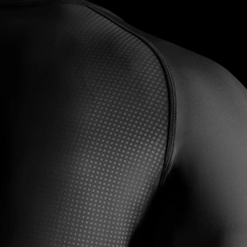 Close-up of a black athletic sleeve with textured pattern on a black background