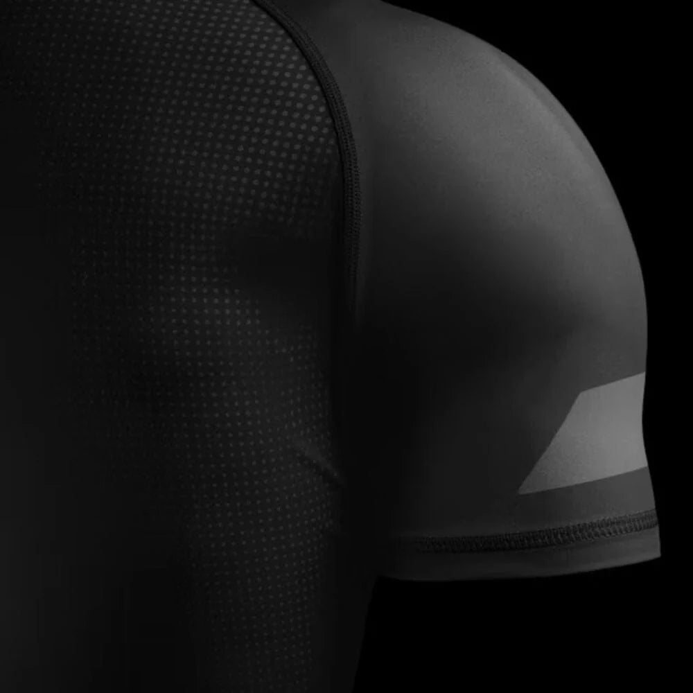 Black athletic shirt with textured shoulder design on a black background