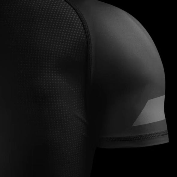 Black athletic shirt with textured shoulder design on a black background
