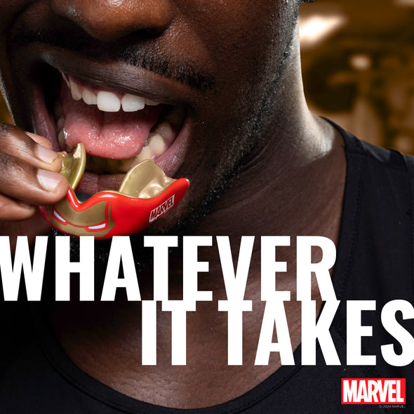 Person holding a Marvel mask with text 'Whatever It Takes' and Marvel logo.