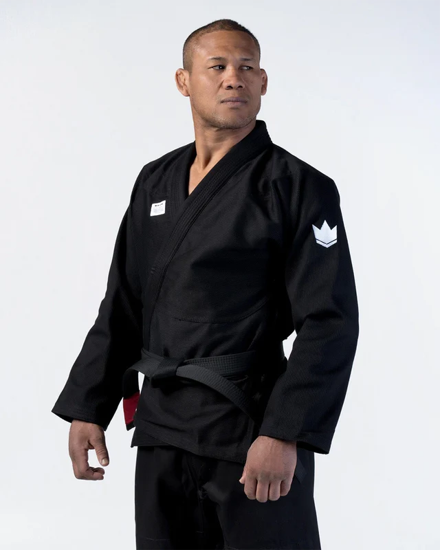 Person wearing a black martial arts uniform with a white logo on a white background