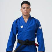 Person wearing a blue martial arts uniform with a black belt on a white background