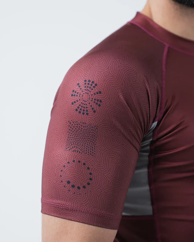 Maroon athletic shirt with geometric pattern on a plain background