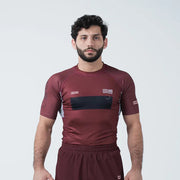Man wearing a maroon athletic outfit with black accents on a white background