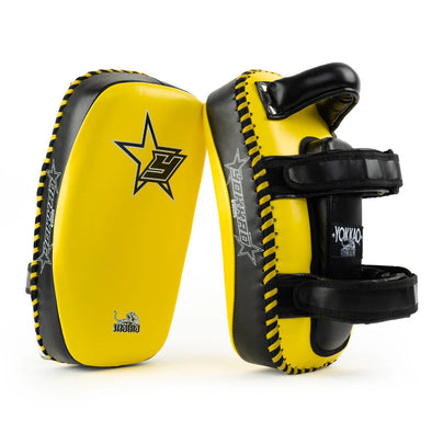 Yellow and black martial arts training pads with visible branding on a white background