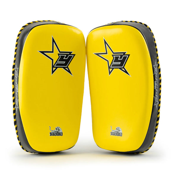 Pair of yellow and black martial arts knee pads with a star logo on a white background