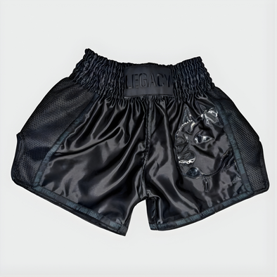 Black boxing shorts with 'Legacy' branding on a light gray background