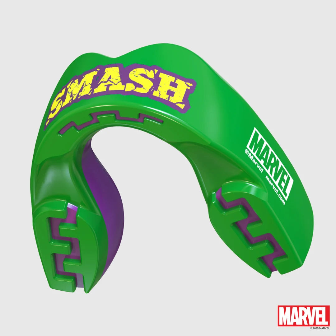 A green and purple Marvel Smash mouthguard with yellow 'SMASH' lettering, shown on a light gray background with a Marvel logo in the bottom right corner.
