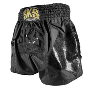 Black and gold boxing shorts with 'SKS' branding on a gray background