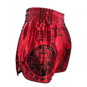 Red boxing shorts with black text and graphics on a gray background