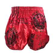Red boxing shorts with black text and graphics on a gray background
