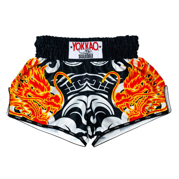 Black shorts with fiery dragon design and Yokkao branding on a white background