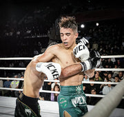 Boxer in action during a match with 'Nike' branded gloves and shorts.
