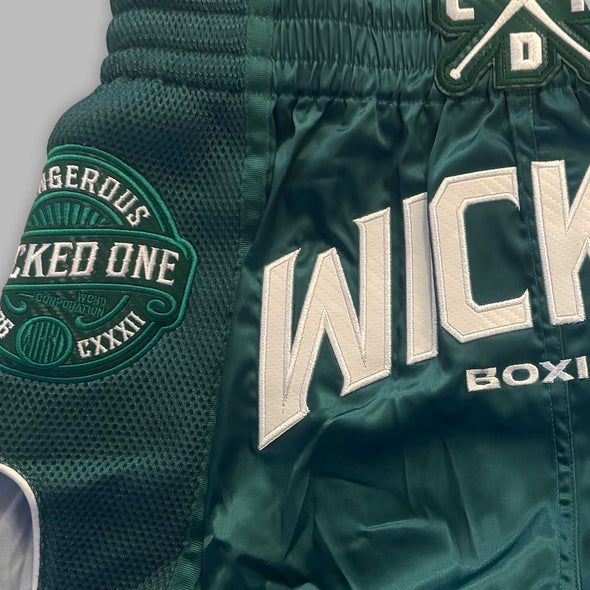 Green boxing shorts with 'Wicked One' branding on a gray background