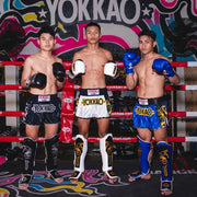 Three boxers in a boxing ring with Yokkao gear and branding.