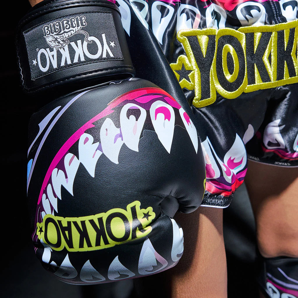 Black boxing gloves with shark design and 'Yokkao' branding on a dark background