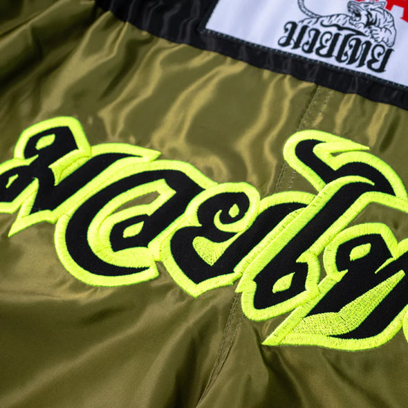 Green shorts with black and yellow text and a brand logo on a white background