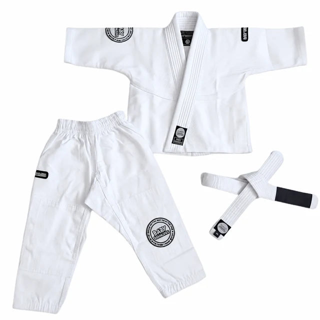 A white Brazilian Jiu-Jitsu (BJJ) gi set laid out on a white background, including a gi jacket, matching pants, and a belt. The gi features circular black and white patches on the chest and thigh, and a black-and-white belt.