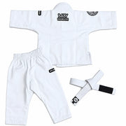 White Brazilian Jiu-Jitsu gi set for babies, including a long-sleeve top, matching pants, and a white belt with black patches, laid out on a white background.