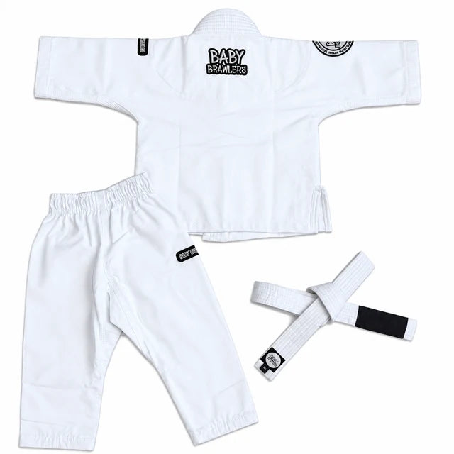 White Brazilian Jiu-Jitsu gi set for babies, including a long-sleeve top, matching pants, and a white belt with black patches, laid out on a white background.