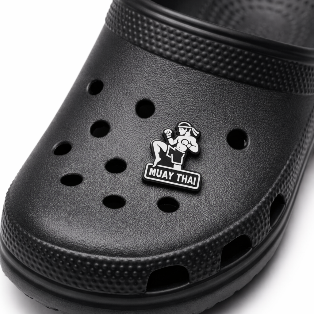 Black clog shoe with a Muay Thai logo on a white background