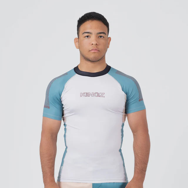 Man wearing a white and blue athletic shirt with 'Kanez' branding on a light gray background