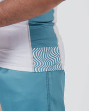 Teal and white athletic shorts with a wavy pattern on a white background