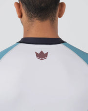 Person wearing a white and blue shirt with a logo on the back against a light gray background