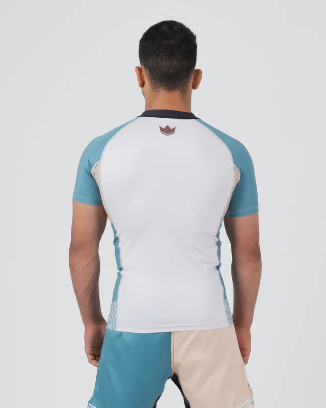 Person wearing a white and blue sports shirt with a visible brand logo on a light gray background