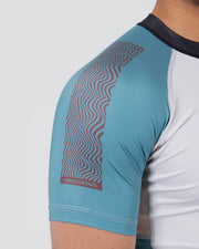 Close-up of a blue athletic shirt with a patterned arm section on a white background