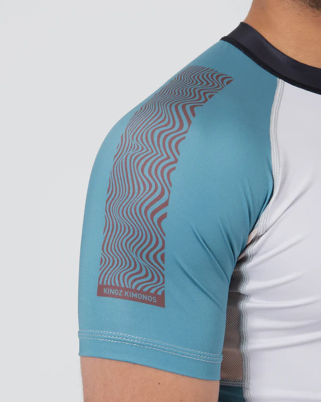 Close-up of a blue athletic shirt with a patterned arm section on a white background