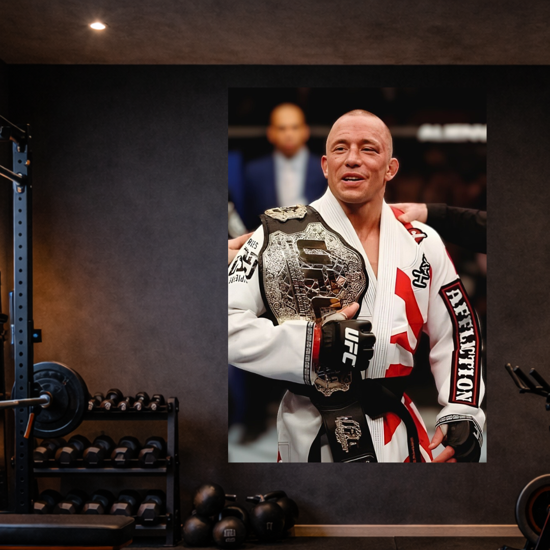 Person in a martial arts uniform holding a championship belt in a gym setting